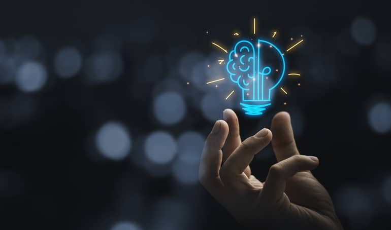 Hand holding drawing virtual lightbulb with brain on bokeh background for creative and smart thinking idea concep Every business encounters obstacles, the answer lies in stepping back, strategy, and working smarter.